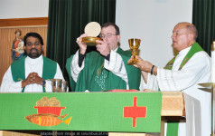 Priests Lifting Host and Chalice at Altar