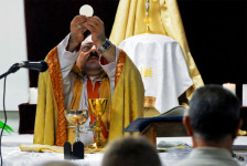Bishop Holding Host Aloft During Mass