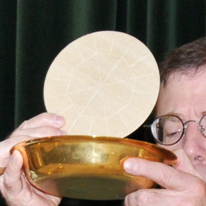 Priest Lifting Large Host