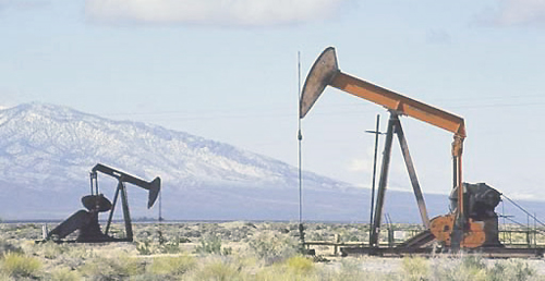 File Photo of Oil Wells with Mountains in Background, adapted from image at blm.gov by Steven C. Welsh www.stevencwelsh.info :: www.stevencwelsh.com
