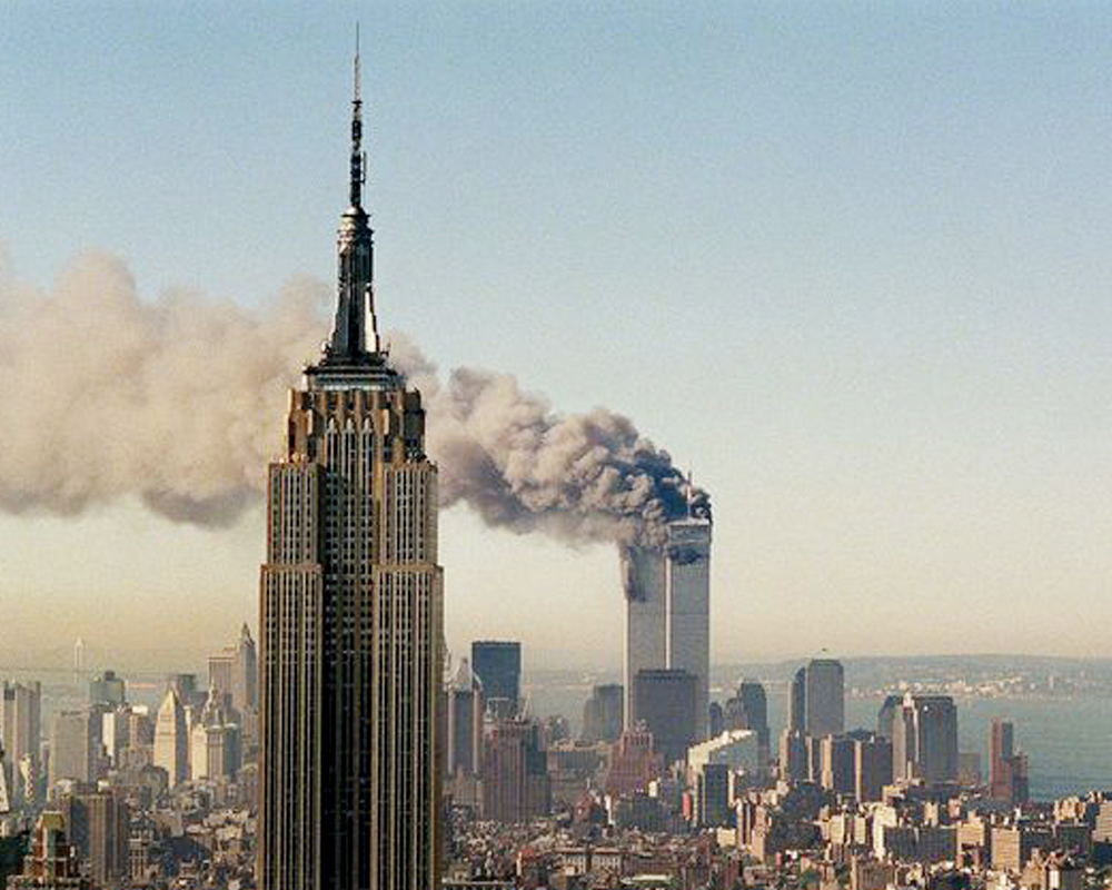 Emprire State Building With World Trade Center Towers Smoking and On Fire in Background, adapted from defense.gov photo