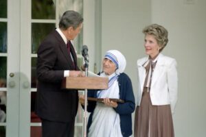 Saint Mother Teresa of Calcutta Receiving Presidential Medal of Freedom from President Ronald Reagan (at podium) as First Lady Nancy Reagan Looks On