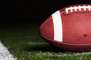 Football on Turf Near Yard Marker